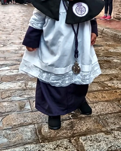 Monaguillo con roquete blanco de encaje, esclavina negra con escudo y medalla de hermandad, hecho por Esperanza, costurera en Dos Hermanas