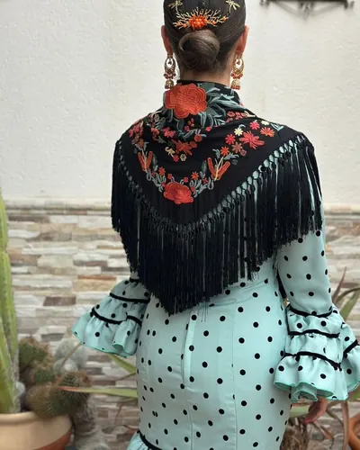 Traje de flamenca aguamarina de lunares con mantón negro bordado, hecho por Esperanza, costurera en Dos Hermanas