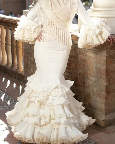Traje de flamenca blanco roto con volantes de puntilla y mantón crudo de flecos, hecho por Nanny, costurera en Mairena del Aljarafe