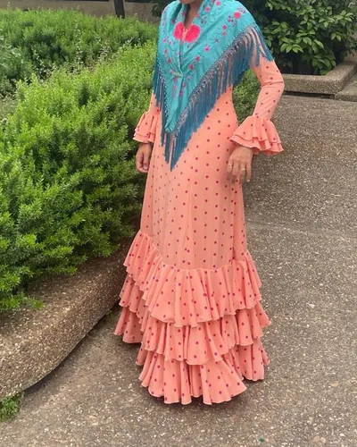 Traje de flamenca melocotón de lunares fucsia con mantón turquesa bordado, hecho por María Eugenia, costurera en Dos Hermanas