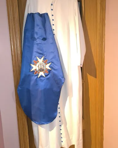 Túnica de nazareno blanca con antifaz azul y cruz bordada, hecho por Vicky, costurera en Alcalá de Guadaíra