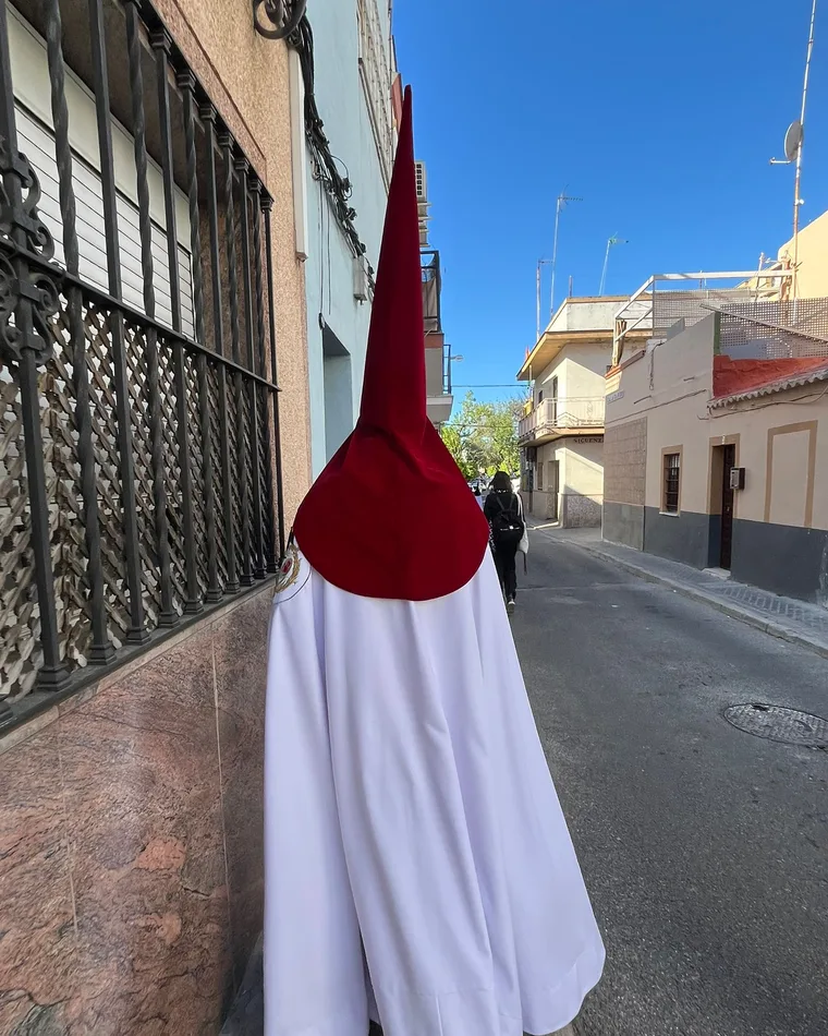 Nazareno de espaldas con túnica blanca y capirote rojo, confeccionado por una costurera de CosiendoTe